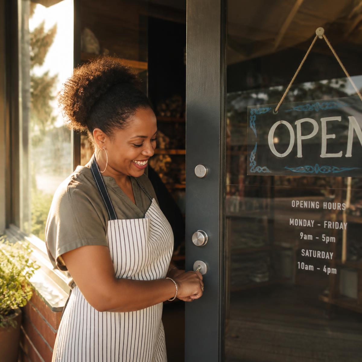 A small business owner unlocking the door of her shop on opening morning